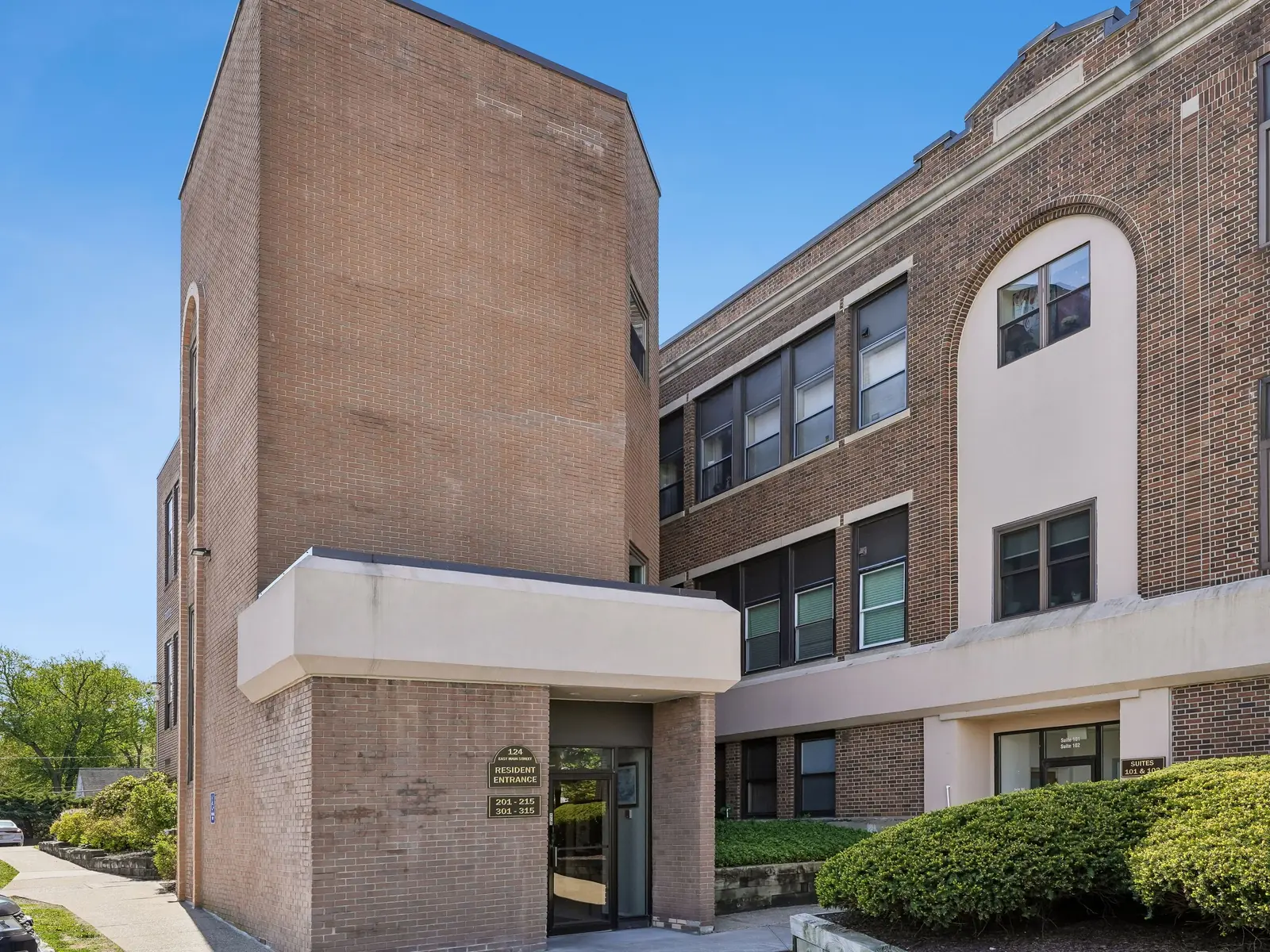 Resident entrance and three-story brick exterior of School House Plaza Condominiums at 124 East Main Street, Denville NJ